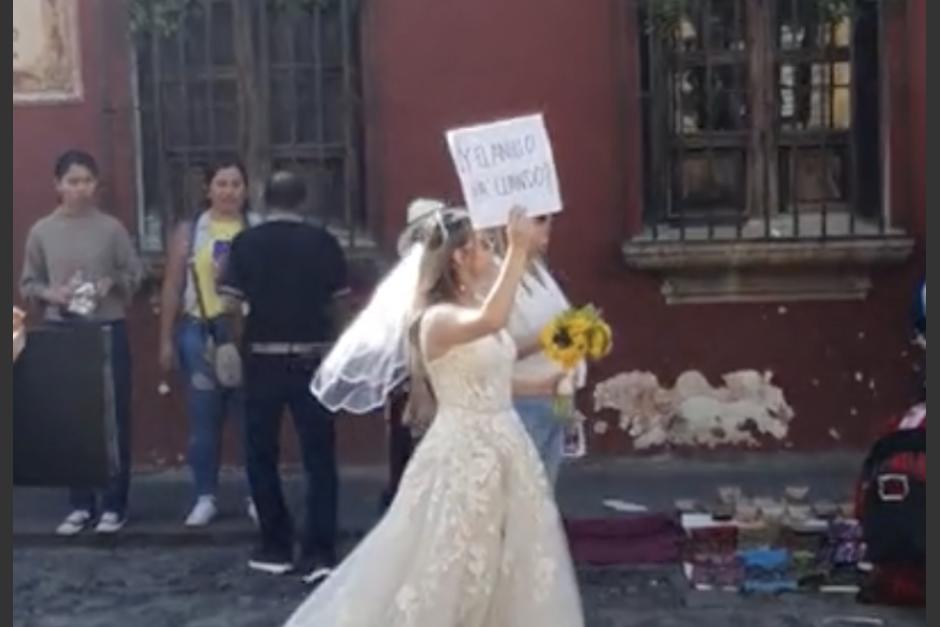 La joven vestida de novia atrajo miradas por un peculiar mensaje que llevaba. (Foto: captura de video)