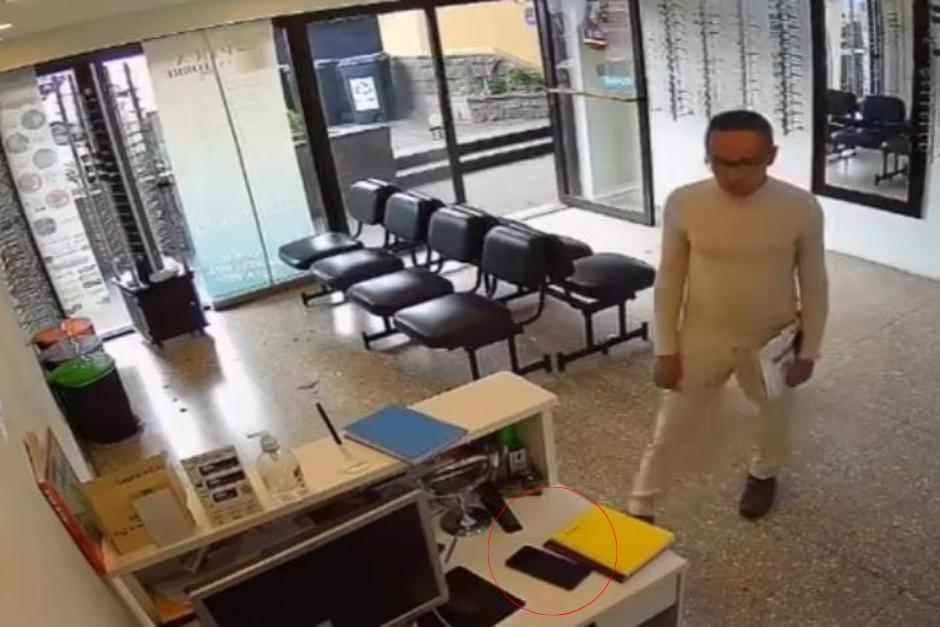 Aunque al inicio duda en agarrar el celular, al final, lo esconde en una revista y ser retira del lugar. (Imagen: captura de pantalla)