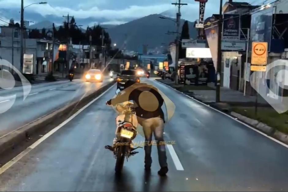 Una persona en aparente estado de ebriedad empuja una motocicleta en la vía pública. (Foto: redes sociales / Soy502)