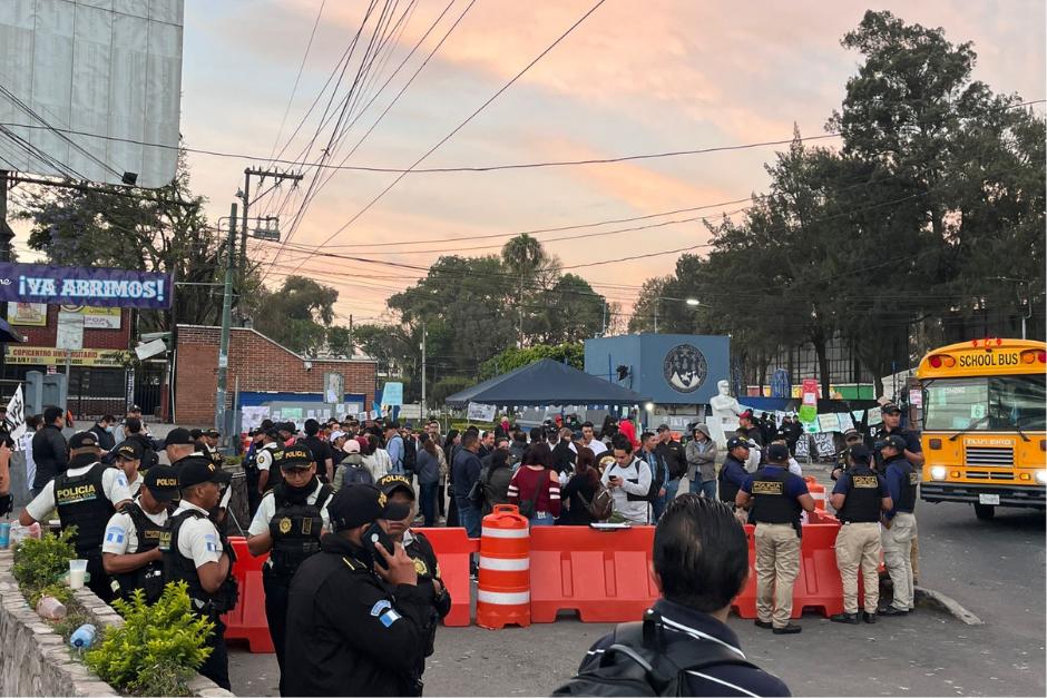 Presuntos estudiantes y fuerzas de seguridad se encuentran en la entrada del centro universitario. (Foto: Fredy Hern&aacute;ndez/Soy502)