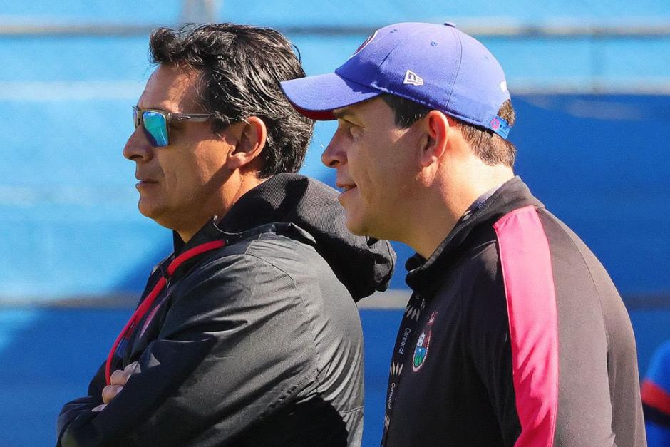 Mario Acevedo y su asistente Dwight Pezzarossi buscar&aacute;n que el Clausura 2026 sea el de la 33 para los rojos. (Foto: Municipal)