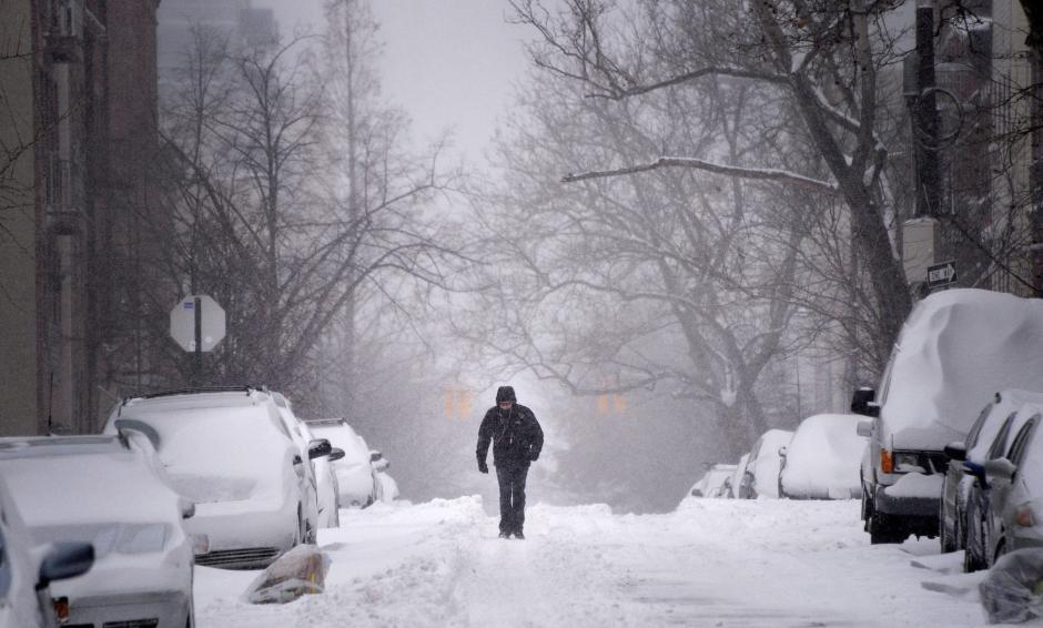 Un hombre camina por una calle cubierta de nieve en el distrito de Brooklyn en Nueva York, el 3 de enero de 2014. (EFE)