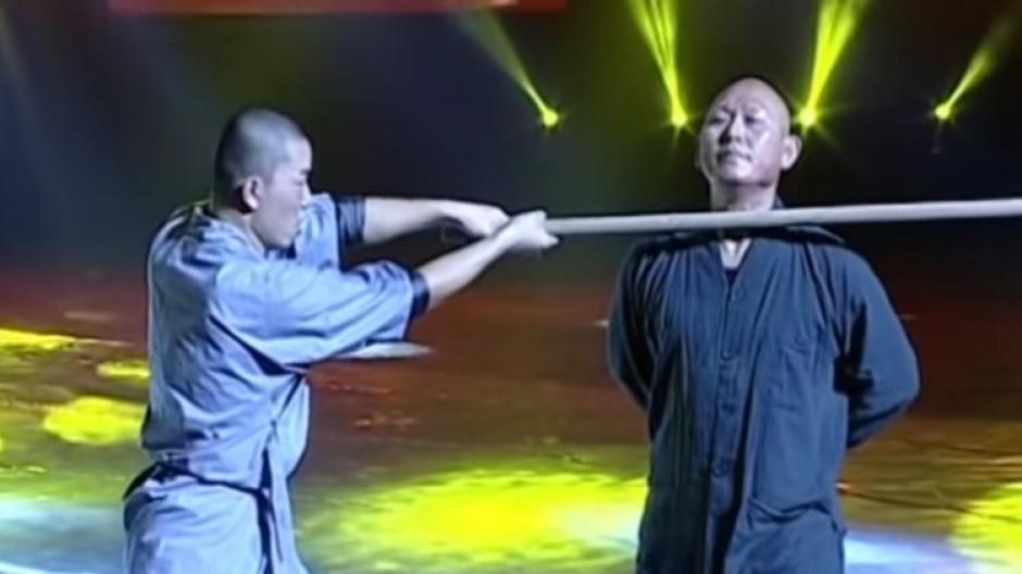 El monje demuestra su fuerza al quebrar un palo ayudado solo por su cuello.
