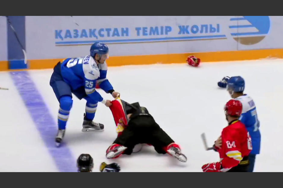 El agresor, de azul, empieza a golpear a cuanto rival encuentra sobre la pista de hielo. (Captura YouTube)