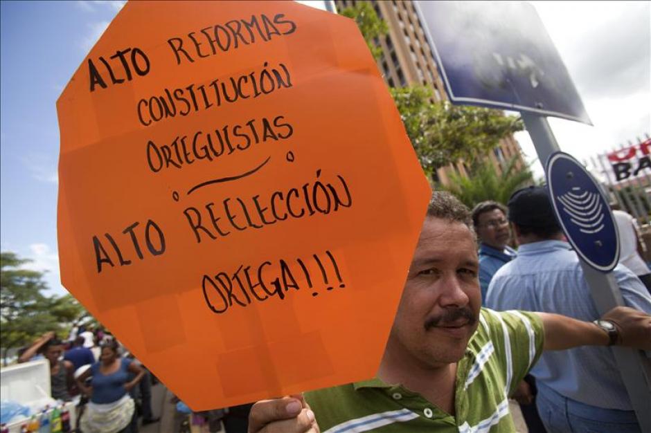 Un hombre con una pancarta se manifiesta contra un paquete de reformas promovidas por el oficialismo, frente al Parlamento.(EFE)