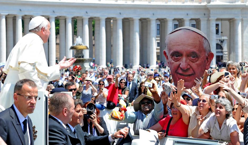 El papa Francisco saluda a un grupo de fieles que sujetan una pancarta con su rostro, a su llegada a la audiencia general de los mi&eacute;rcoles, en la Plaza de San Pedro, en la Ciudad del Vaticano ayer. (Foto: EFE)