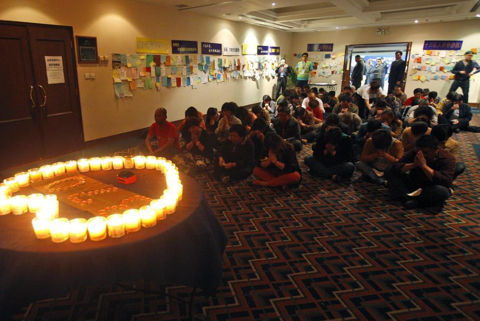 Familiares de los pasajeros desaparecidos en el vuelo MH370 de Malaysia Airlines rezan por encontrarlos. La b&uacute;squeda del avi&oacute;n se realiza ahora bajo el agua. (Foto:Efe)&nbsp;