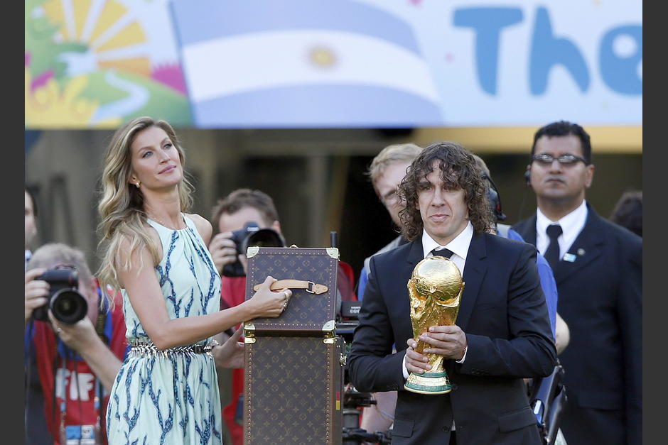 Carles Puyol y Gisele B&uuml;ndchen fueron los encargados de llevar el trofeo de la Copa hasta el c&eacute;sped del Maracan&aacute;. (Foto: EFE)