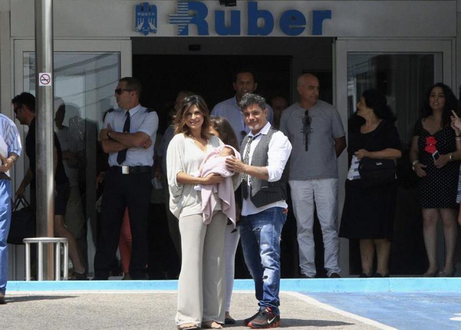 El m&uacute;sico vestido con camisa blanca, con un chaleco gris, una peque&ntilde;a corbata y pantal&oacute;n azul sali&oacute; del centro hospitalario junto a su mujer que vest&iacute;a un pantal&oacute;n ajustado de color claro y una blusa a rayas y llevaba a su hija arropada en una frazada rosa. (Foto: EFE)