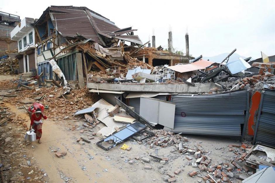 Una mujer nepal&iacute; traslada sus pertenencias un d&iacute;a despu&eacute;s del nuevo terremoto. (Foto: EFE)