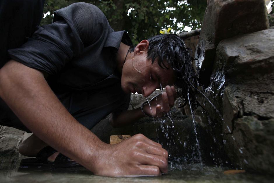 Las altas temperaturas provocadas por el calor en regiones de Pakist&aacute;n han obligado a cientos de personas refrescarse a diario con la poca agua con que cuenta. (Foto: EFE)&nbsp;