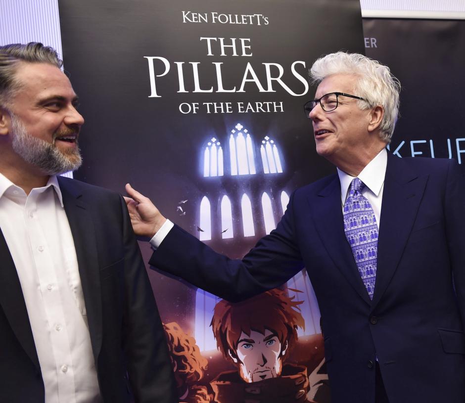 El c&eacute;lebre autor brit&aacute;nico Ken Follett bromea con el director general de Daedalic Entertainment, Carsten Fichtelmann, durante la presentaci&oacute;n videojuego "Los Pilares de la Tierra" en la Feria del Libro de Fr&aacute;ncfort Alemania. El videojuego saldr&aacute; a la venta en 2017. (Foto: EFE/Arne dedert)