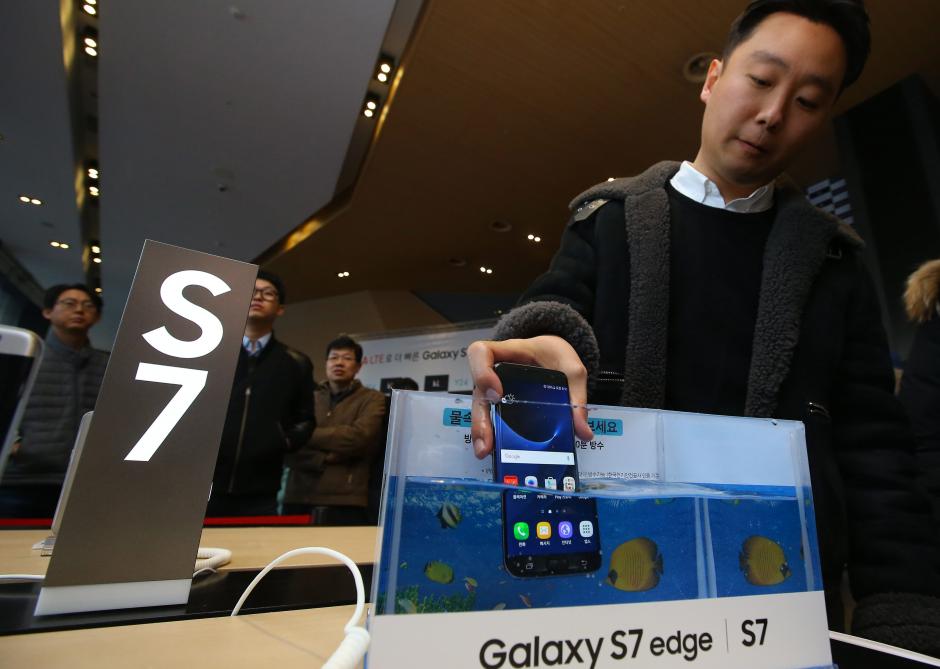 Un cliente sumerge un ejemplar del nuevo celular Galaxy S7 de la empresa Samsung Electronics Co. en una pecera para probar su resistencia al agua durante su lanzamiento en Se&uacute;l (Corea del Sur). (Foto: EFE/Yonhap)