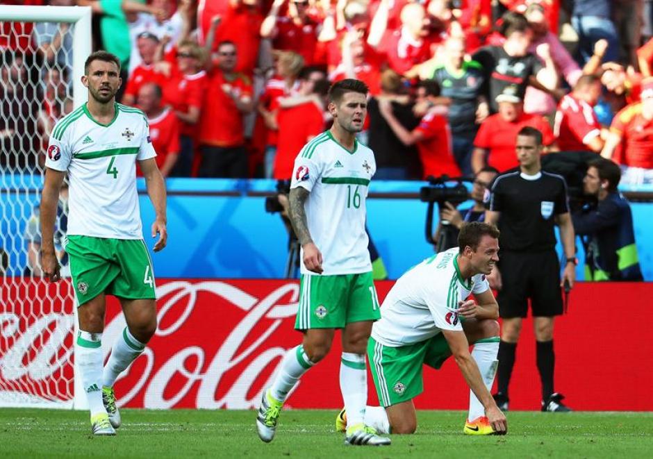 Los jugadores lamentan el autogol de McAuley (EFE)