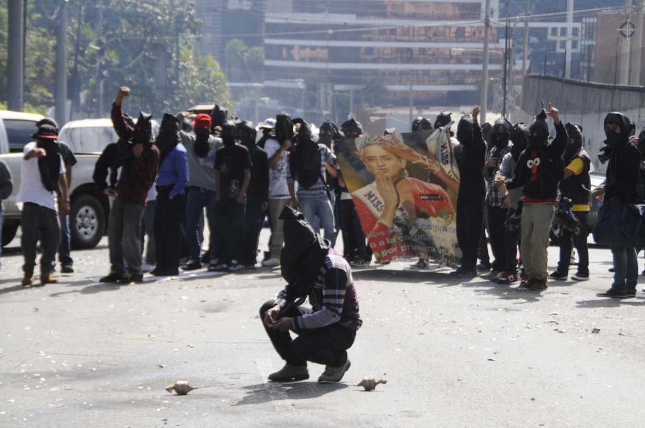 Un grupo de encapuchados identific&aacute;ndose como miembros de la Asociaci&oacute;n de Estudiantes de la Universidad de San Carlos rodearon los accesos al Teatro Nacional para realizar una protesta en contra de la presentaci&oacute;n del 2o. Informe de Gobierno de Otto P&eacute;rez. Los manifestantes portaban carteles y bombas pirot&eacute;cnicas para llamar la atenci&oacute;n de los invitados al acto. Foto Esteban Biba/Soy502