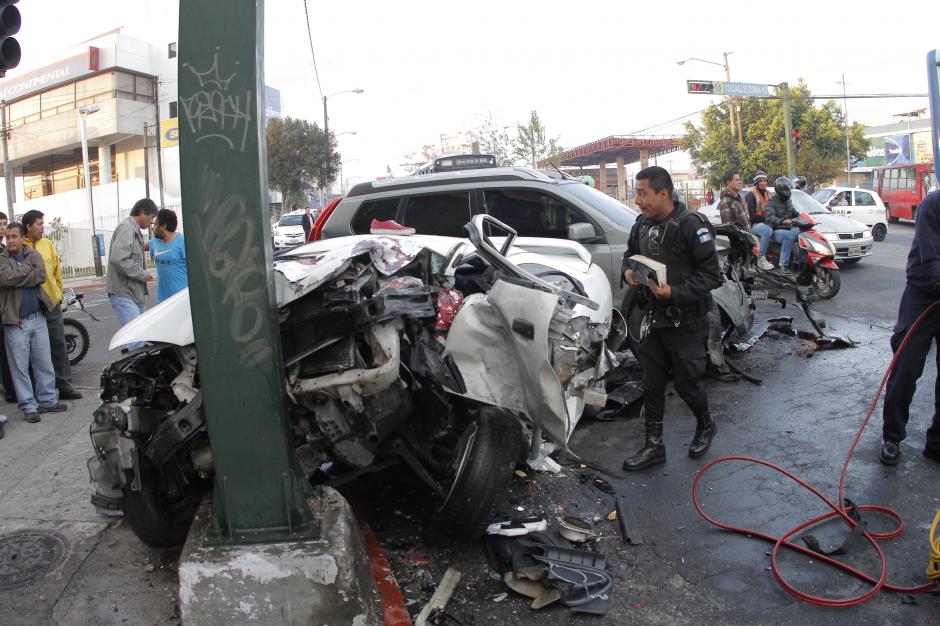 El agente de la PNC se acerca al veh&iacute;culo colisionado para observar qu&eacute; hay adentro. (Foto: Ren&eacute; Ruano/Nuestro Diario)
