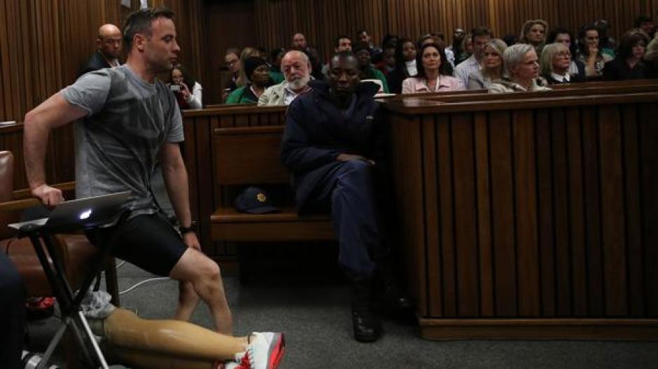 Oscar Pistorius se levanta ante el juzgado que lo acusa del asesinato de su prometida Reeva Steenkamp. (Foto: AFP)