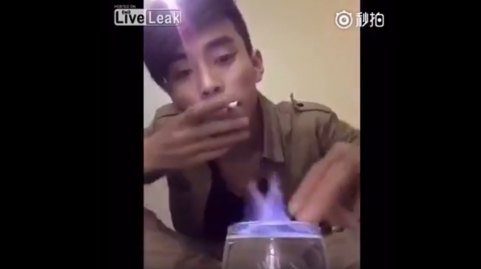 Un joven enciende un cigarro con fuego que sale de un vaso de alcohol. (Captura de pantalla: YouTube/Liveleak)