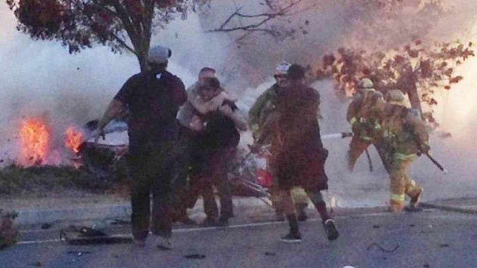 La Policía sujeta a los amigos de Paul Walker, que buscaban rescatarlo a él y a Roger Rodas del vehículo en llamas. (Fuente: TMZ)