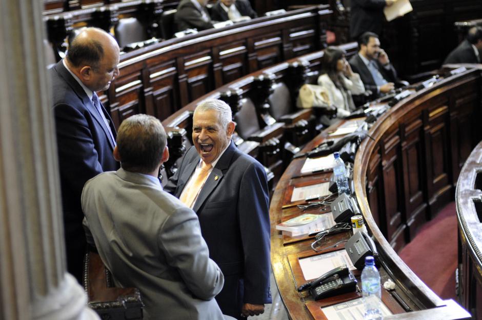 El diputado oficialista Amildo de Jes&uacute;s Rodr&iacute;guez r&iacute;e luego de un comentario de sus colegas; mientras, en el fondo el hemiciclo se observa vac&iacute;o con algunos diputados que prestan poca atenci&oacute;n a la lectura de las iniciativas de Ley. (Esteban Biba/Soy502)