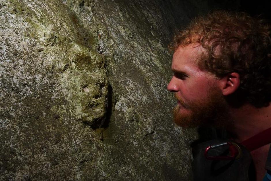 El arque&oacute;logo Greg Schwab observando una cara grabada en una cueva de la regi&oacute;n de los Nueve Cerros.