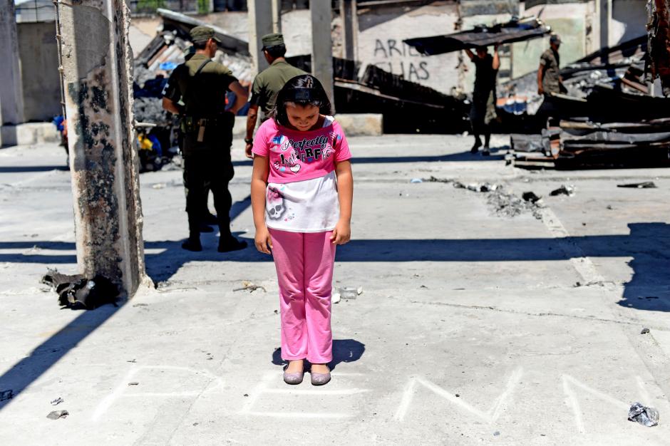 Una estudiante ve el texto trazado con piedra, que conserva el lugar donde antes funcion&oacute; el Programa Educativo del NI&ntilde;o y Ni&ntilde;a, Adolescente Trabajador PENNAT. (Foto: Esteban Biba/Soy502)&nbsp;