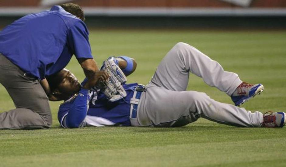 El pelotero cubano, Yasiel Puig, fue retirado el campo, tras sufrir un feurte choque con su compa&ntilde;ero, Howie Kendrick, en partido de pretemporada 2015. (Foto. EFE)