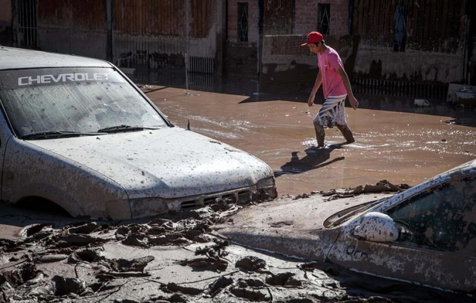 Las personas caminan a&uacute;n por las calles inundadas en la localidad de Paipote en Chile. &nbsp;(Foto: EFE)&nbsp;