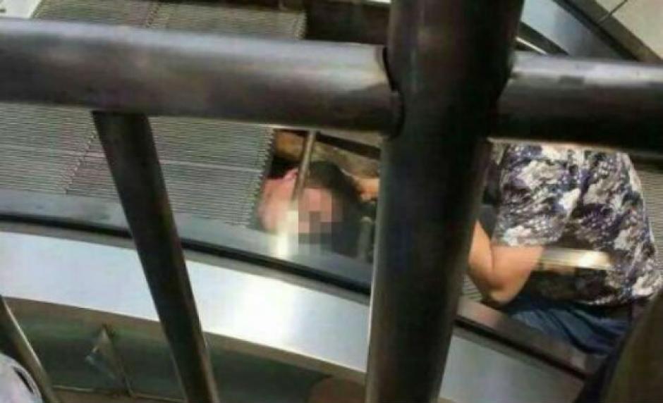 El hombre iba a arreglar las escaleras el&eacute;ctricas y casi muere atrapado. (Foto: shanghaiist.com)