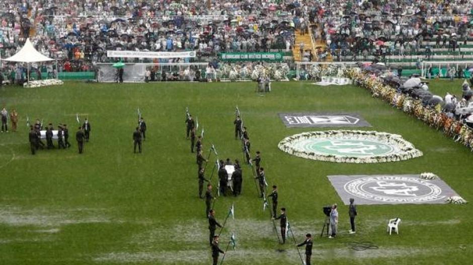 Las fuerzas de seguridad hacen guardia a las v&iacute;ctimas sobre el c&eacute;sped del estadio. (Foto: Infobae)