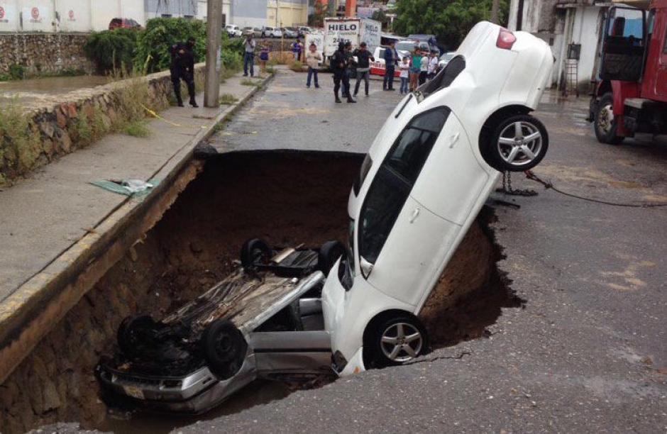 Los carros quedaron atrapados dentro de un hoyo en una calle de Acapulco debido a un socav&oacute;n provocado por las lluvias. (Foto: Alejandro Villalvazo)