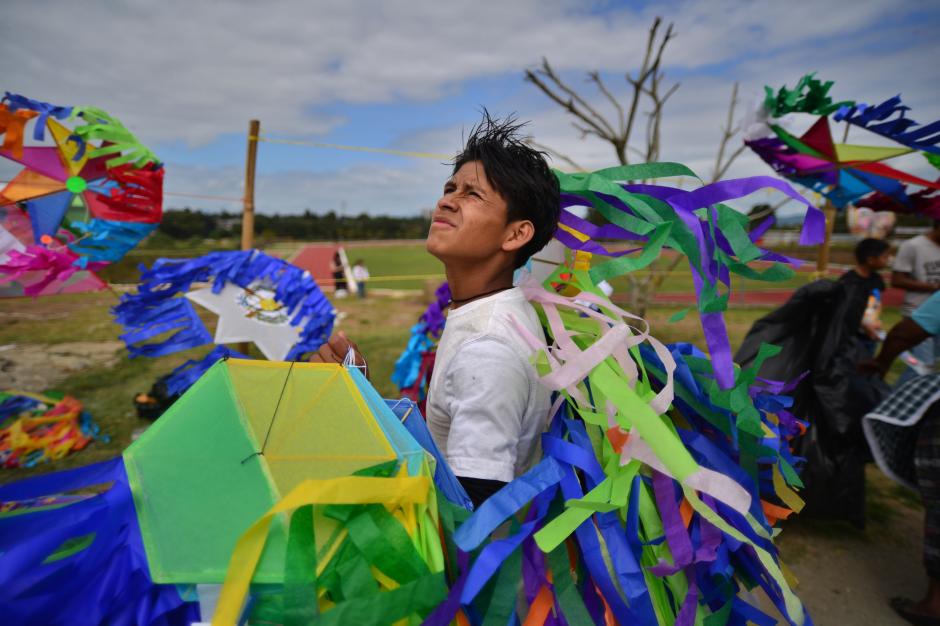 Un vendedor de barriletes se entretiene cuando observa como el viento hace de las suyas con las cometas que vuelan a lo lejos. (Foto: Wilder L&oacute;pez/Soy502)