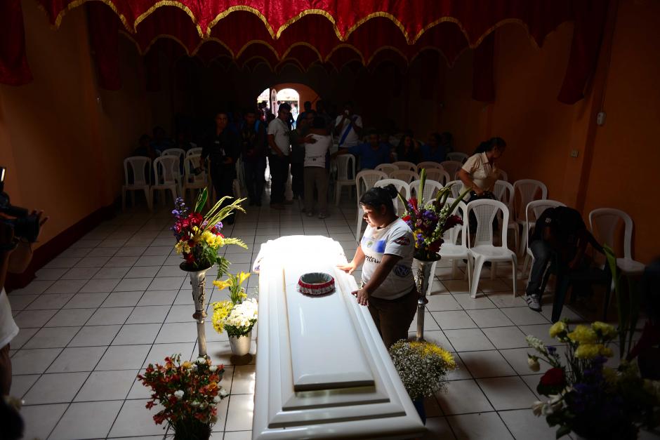 La hermana de Kevin D&iacute;az ora junto al f&eacute;retro, durante el velatorio en la iglesia evang&eacute;lica Luz y Vida de San Miguel Petapa, previo a que el equipo Crema llegara para ofrecer el p&eacute;same a la familia. (Foto: Jes&uacute;s Alfonso/Soy502)