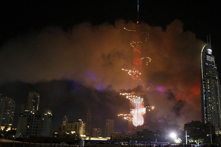 Mientras el edificio continuaba incendi&aacute;ndose, el show de luces comenz&oacute; en Dubai, pese a que el humo del otro edificio era a&uacute;n visible. (Foto: AFP)