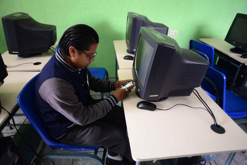 Walter Ixcayá practica inglés con su teléfono porque las computadoras están apagadas del laboratorio de inglés están apagadas y sin internet. &nbsp;(Foto: Jesús Alfonso/Soy502)