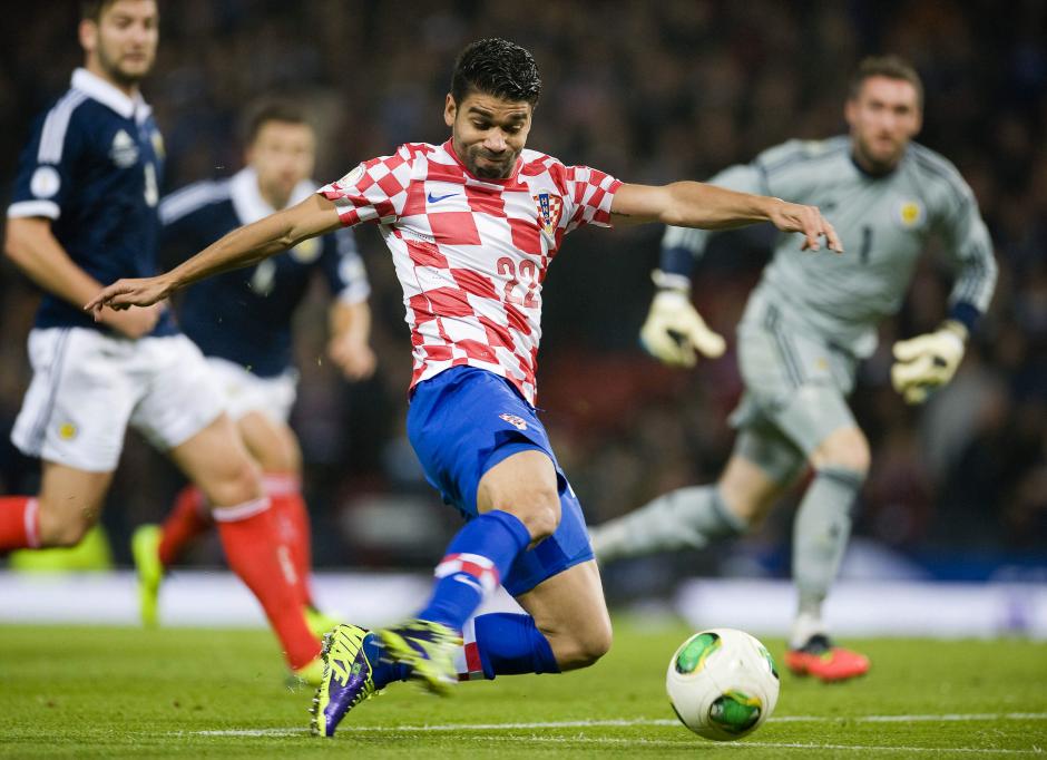 Eduardo disputa un bal&oacute;n en un partido de clasificaci&oacute;n para Brasil ante Escocia. (Foto: EFE)