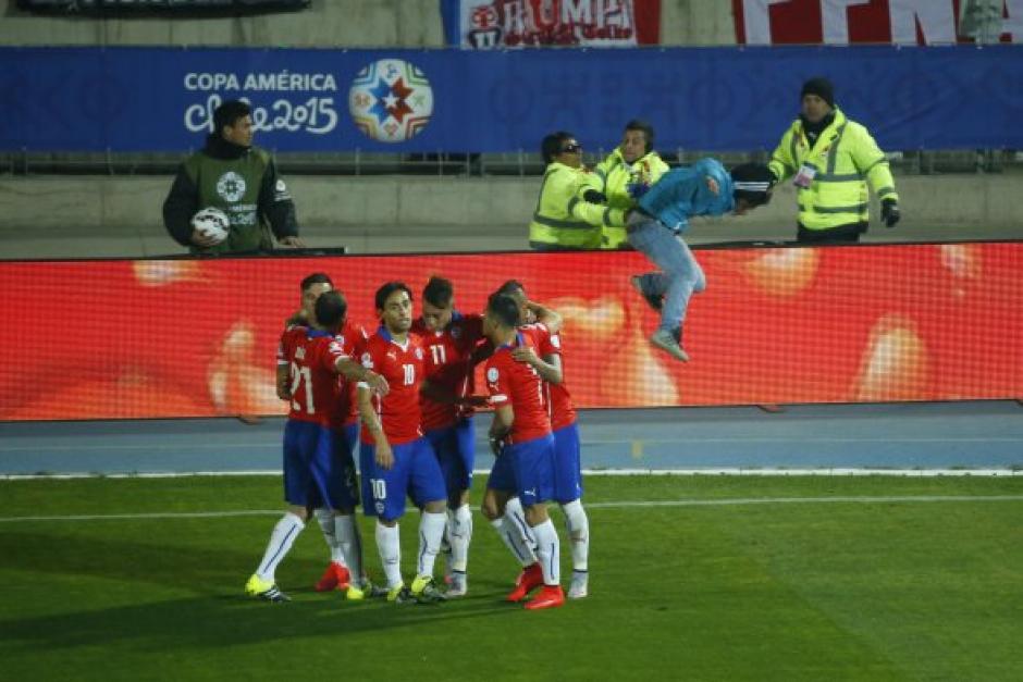 Un aficionado logr&oacute; burlar la seguridad y corre hacia Arturo Vidal, para celebrar el gol chileno. (Foto: Cooperativa.cl)