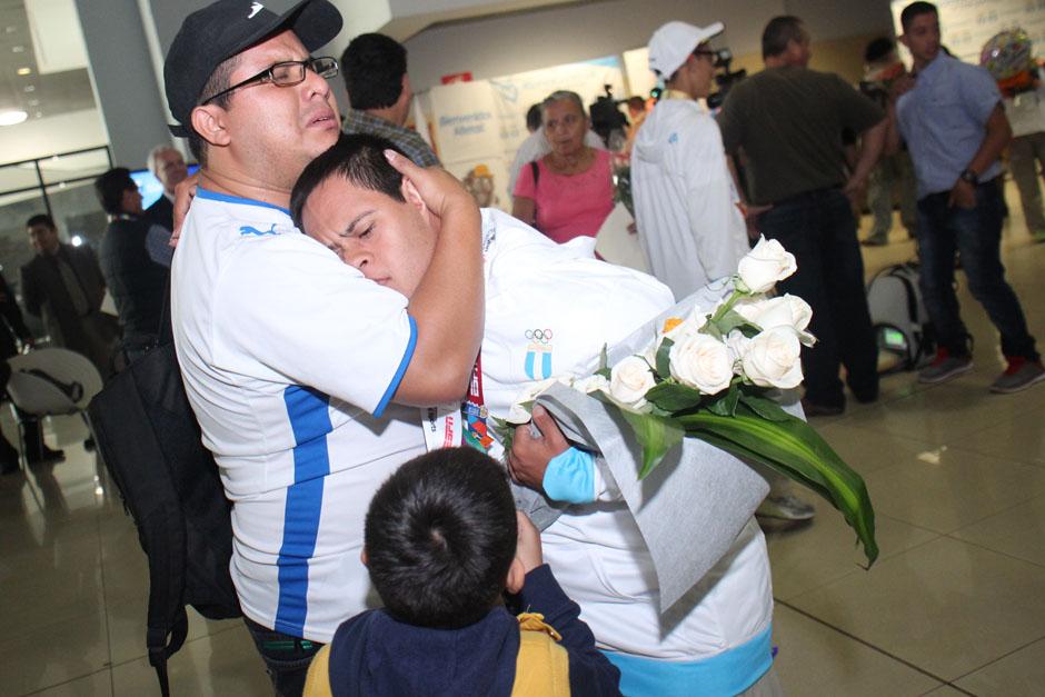 Leonardo Quevedo, uno de los medallistas, recibe un abrazo tras arribar a Guatemala. (Foto: Jos&eacute; D&aacute;vila/Soy502)