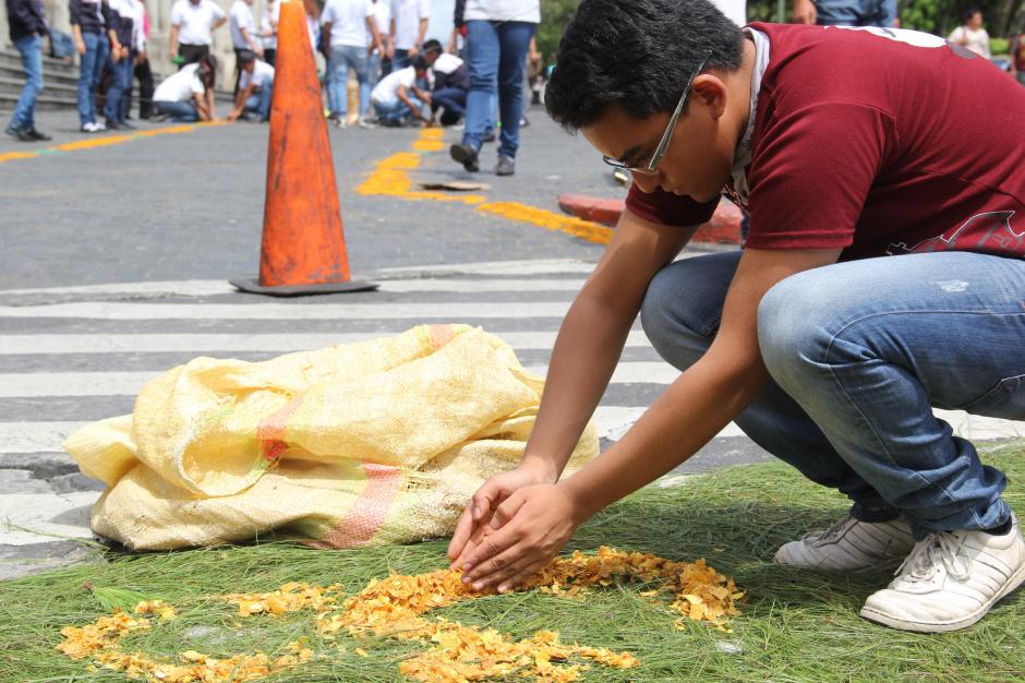 J&oacute;venes estuvieron desde primera hora de la ma&ntilde;ana construyendo las alfombras de serr&iacute;n. (Foto: Roberto Caubilla/Soy502)