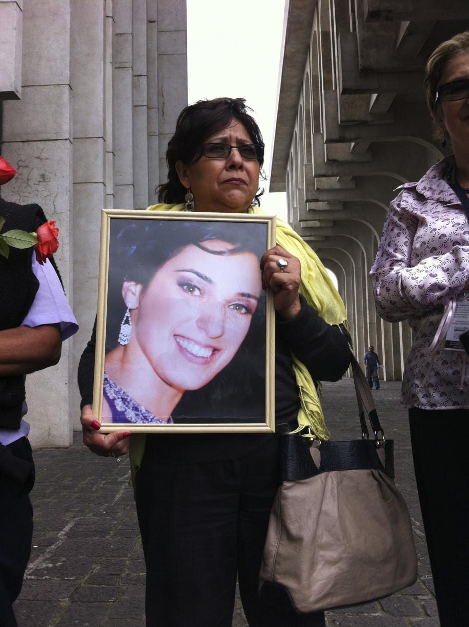 Nora Montoya, de Voces por Cristina, junto a varias de sus compa&ntilde;eras, sostiene una foto de Cristina Siekavizza frente a la Torre de Tribunales. &nbsp;(Foto: Antonio Ordo&ntilde;ez/Soy502)