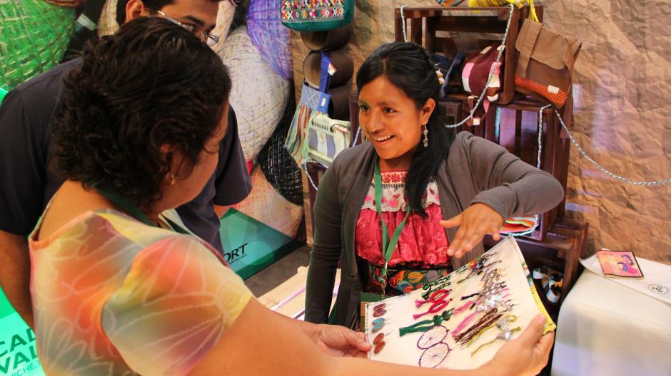 Amadelia Itzep muestra los aretes elaborados con materiales reciclados a los asistentes a la feria ECOnciencia, organizada por AGEXPORT. &nbsp;(Foto: Antonio Ordoñez/Soy502)