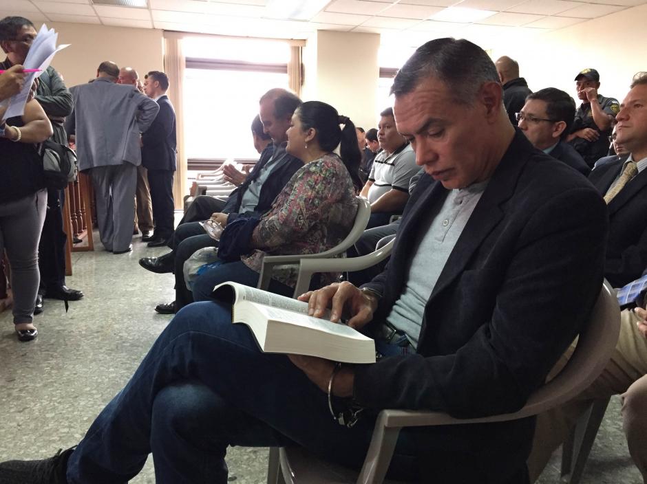 Juan de Dios Rodr&iacute;guez, expresidente de la Junta Directiva del IGSS, lee la Biblia mientras espera el inicio del juicio en su contra. (Foto: Evelyn de Le&oacute;n/Soy502) 