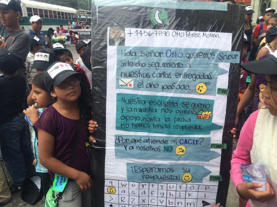 Con un cartel en forma de pantalla de tel&eacute;fono inteligente los ni&ntilde;os trabajadores de Guatemala enviaron un mensaje al presidente Otto P&eacute;rez Molina. (Foto: Luis Barrios/Soy502)