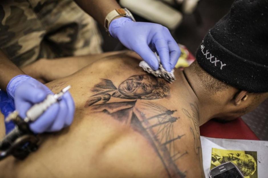 Los sudafricanos han encontrado otra forma de recordar a su expresidente y activista contra el apartheid, Nelson Mandela, al tatuarse la figura de uno los reconocidos mandatarios de ese pa&iacute;s. (Foto: AFP)