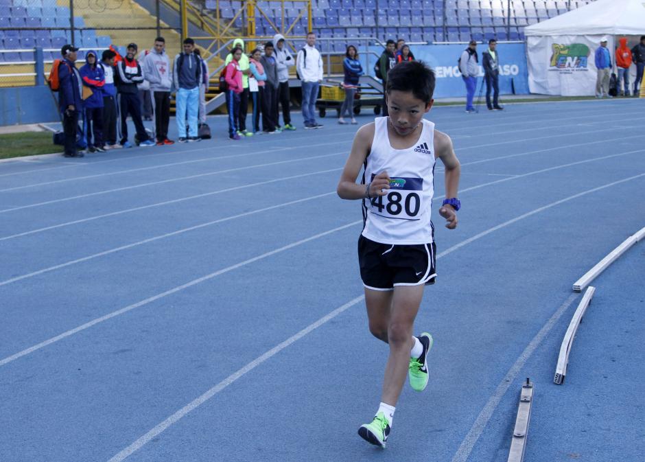 Luis Luciano Tzun&uacute;n, de Quich&eacute;, fue el ganador la categor&iacute;a 3000 metros varoniles, Sub 14. Al fondo de su competencia, los seleccionados de marcha observan la carrera. (Foto: Federaci&oacute;n de Atletismo)