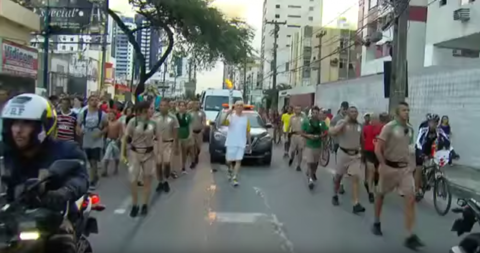Nikita, un ex entrenador de nataci&oacute;n de la selecci&oacute;n brasile&ntilde;a llevaba la antorcha Ol&iacute;mpica. (Captura de pantalla: Tem Muito/YouTube)