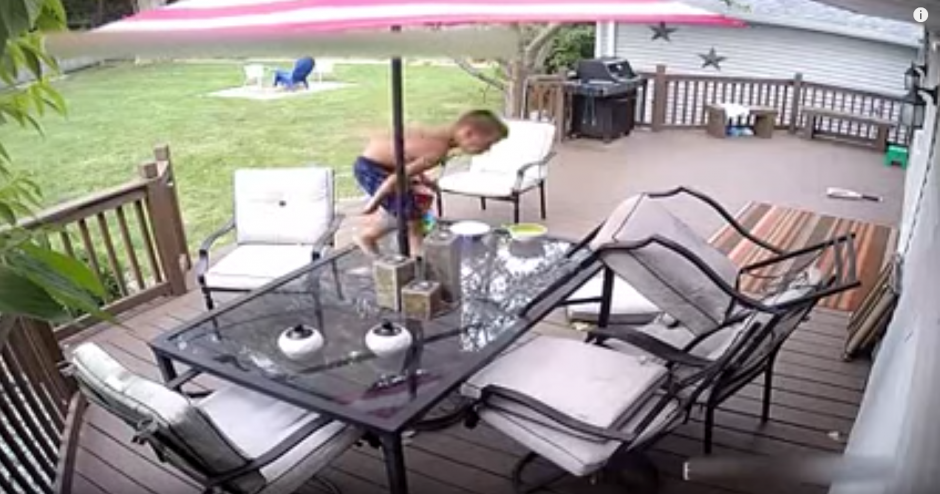 Un ni&ntilde;o juega sobre una mesa de patio que tiene la parte superior de vidrio. (Captura de pantalla: Daily Mail)