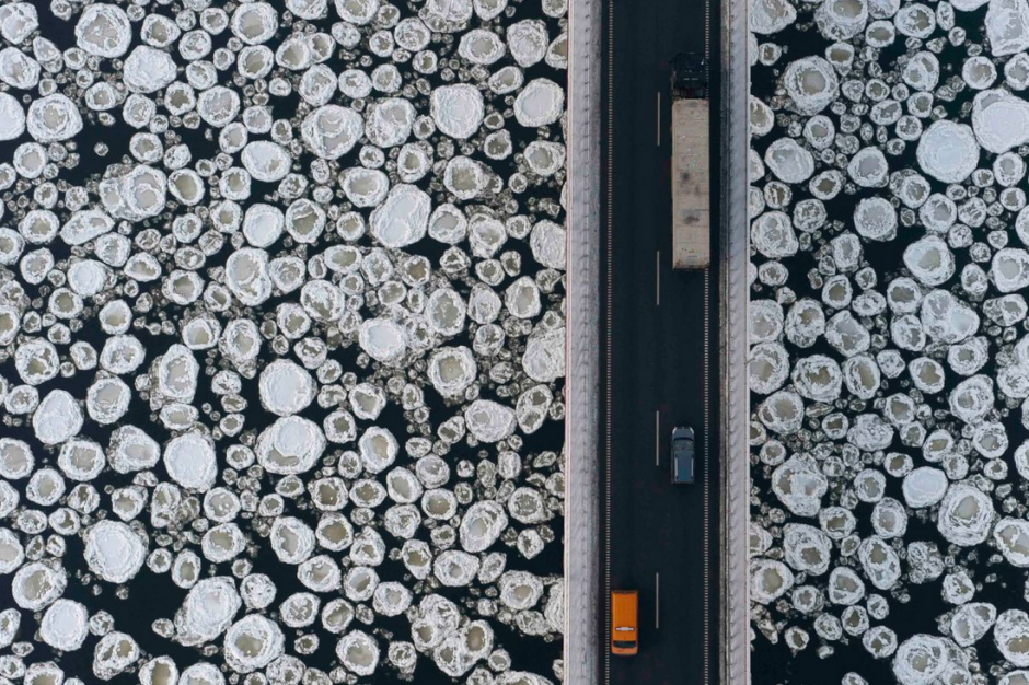 Un grupo de veh&iacute;culos transita por un tramo en donde el hielo cubre al r&iacute;o Vistula cerca de la villa Kiezmark. (Foto: Kacper Kowalski-Panos Pictures)