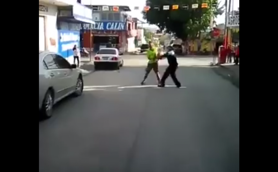 El hombre de verde amenaza al agente con un machete. (Foto: Captura/Facebook)
