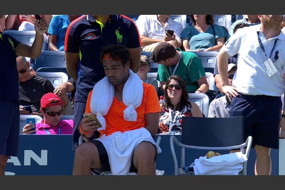 Marcos Baghdatis, est&aacute; en la banca y con el celular en la mano. (Captura de Pantalla)